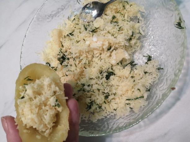 Temidden put aardappelen geraspte kaas met kruiden (in beide helften)