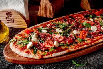 Pizza met salami, champignons en tomaten